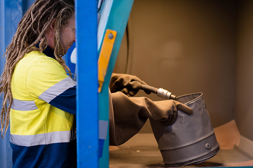 sbting2 Technician from a powdercoating services company doing a sand blast process