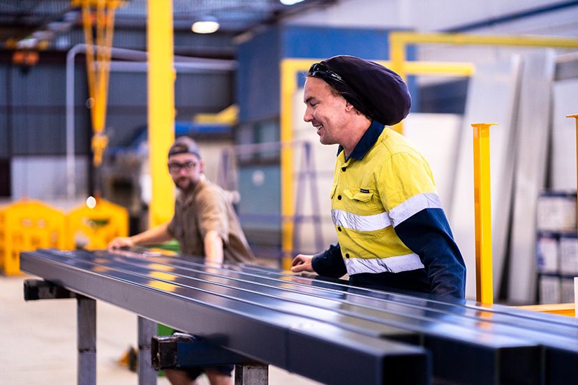 Technicians from a powdercoating services team placing pieces of metals after sandblasting