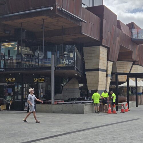 People walking near a large building with one of Precision Powdercoating;'s work